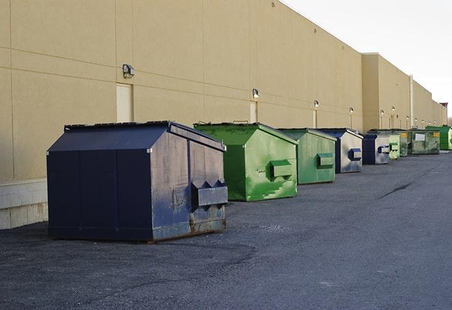 construction dumpsters on a worksite surrounded by caution tape in Manson